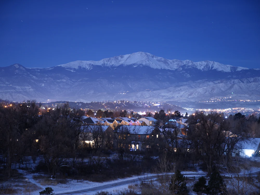 Homes in a Colorado neighborhood below snow-capped mountains